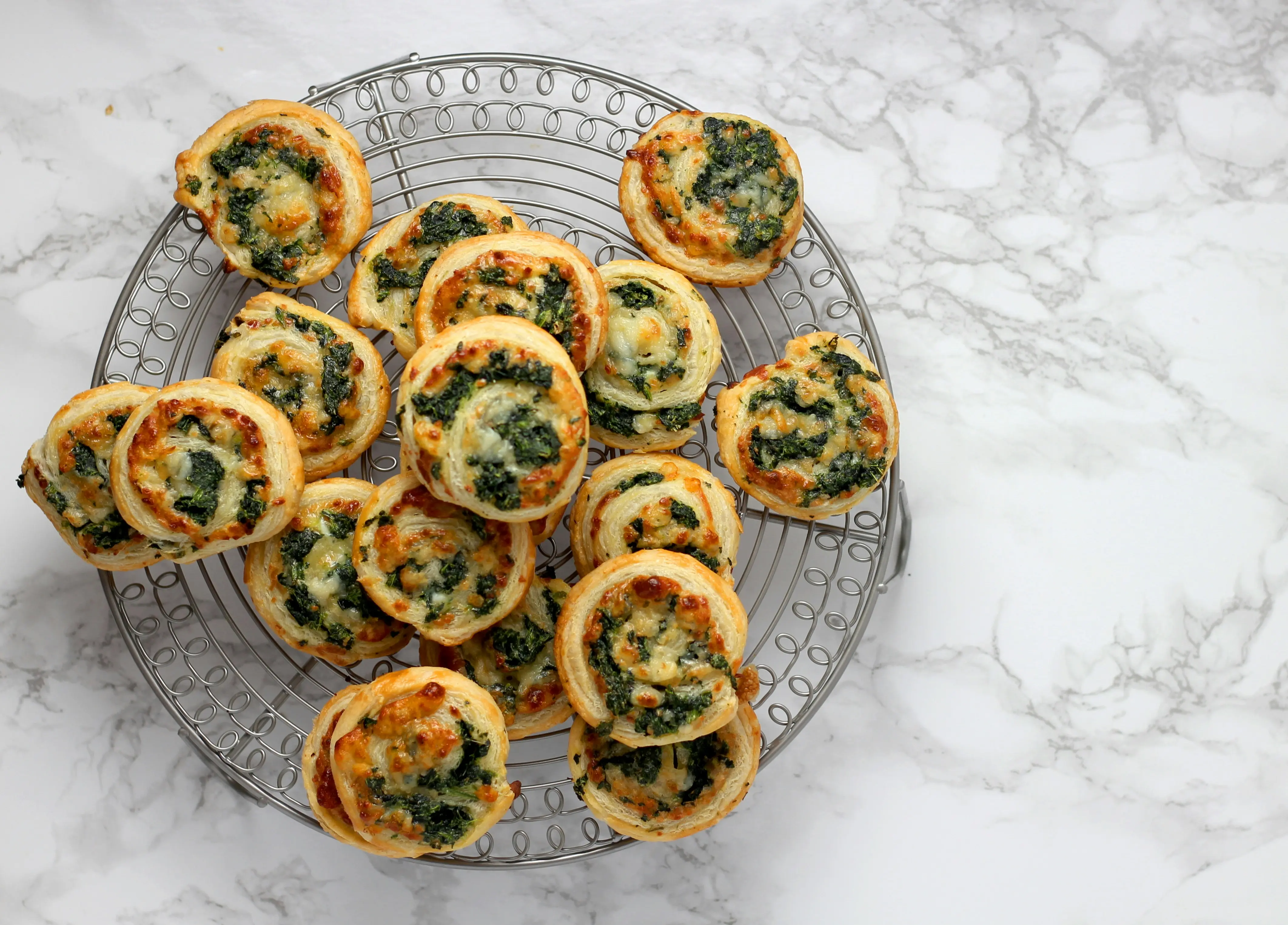 Spinach and cheese puff-pastry pinwheels on a cooling rack